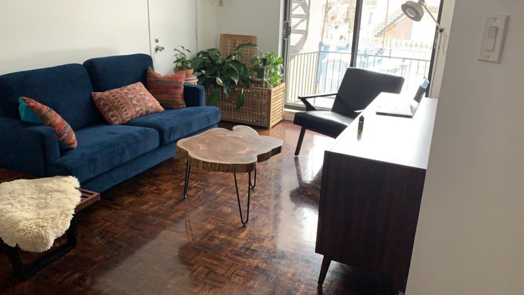 Midcentury modern living room with blue sofa, live edge coffee table and walnut sideboard