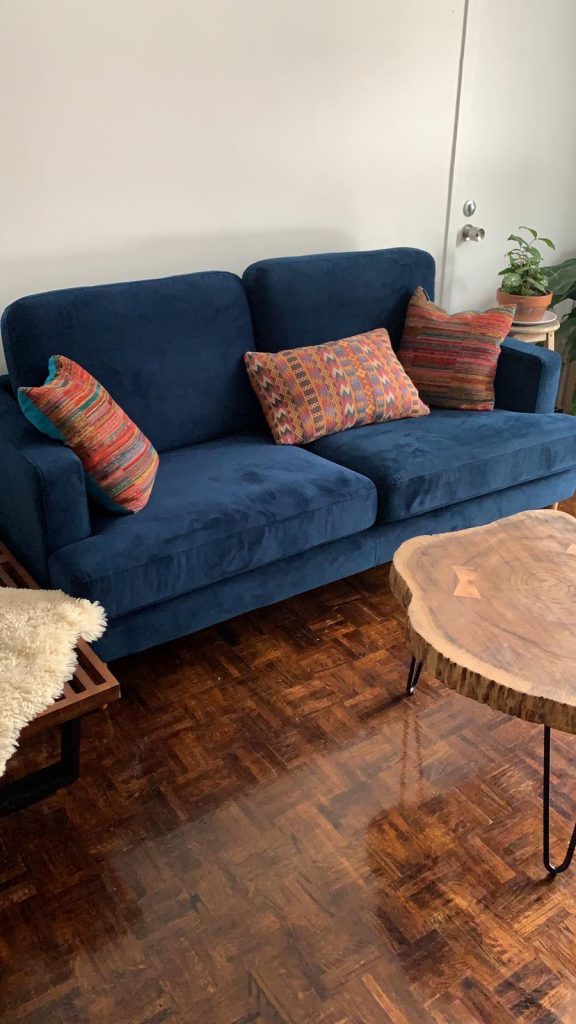 Midcentury modern living room with blue sofa and live edge coffee table