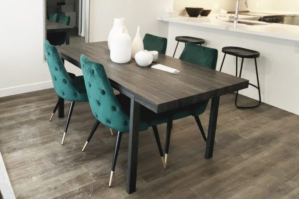 Contemporary dining room with walnut dining table and tufted velvet green dining chairs