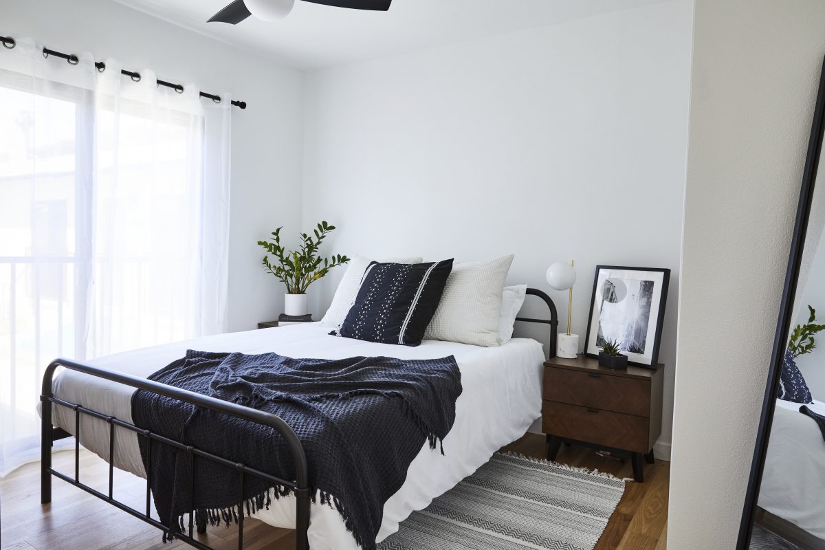 Bedroom with mattress, side table, art, and throw pillows