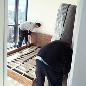 Delivery day - delivery team setting up the bed frame in the bedroom