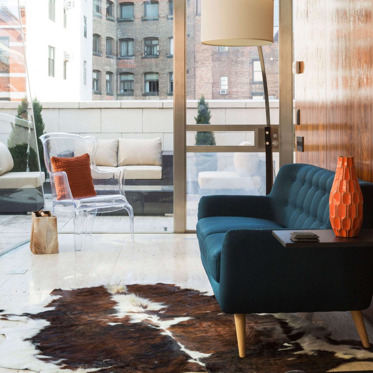 Blue sofa on cowhide rug and glossy walnut wall