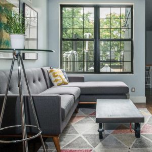 Living room with sectional, colorful rug and colorful wall arts