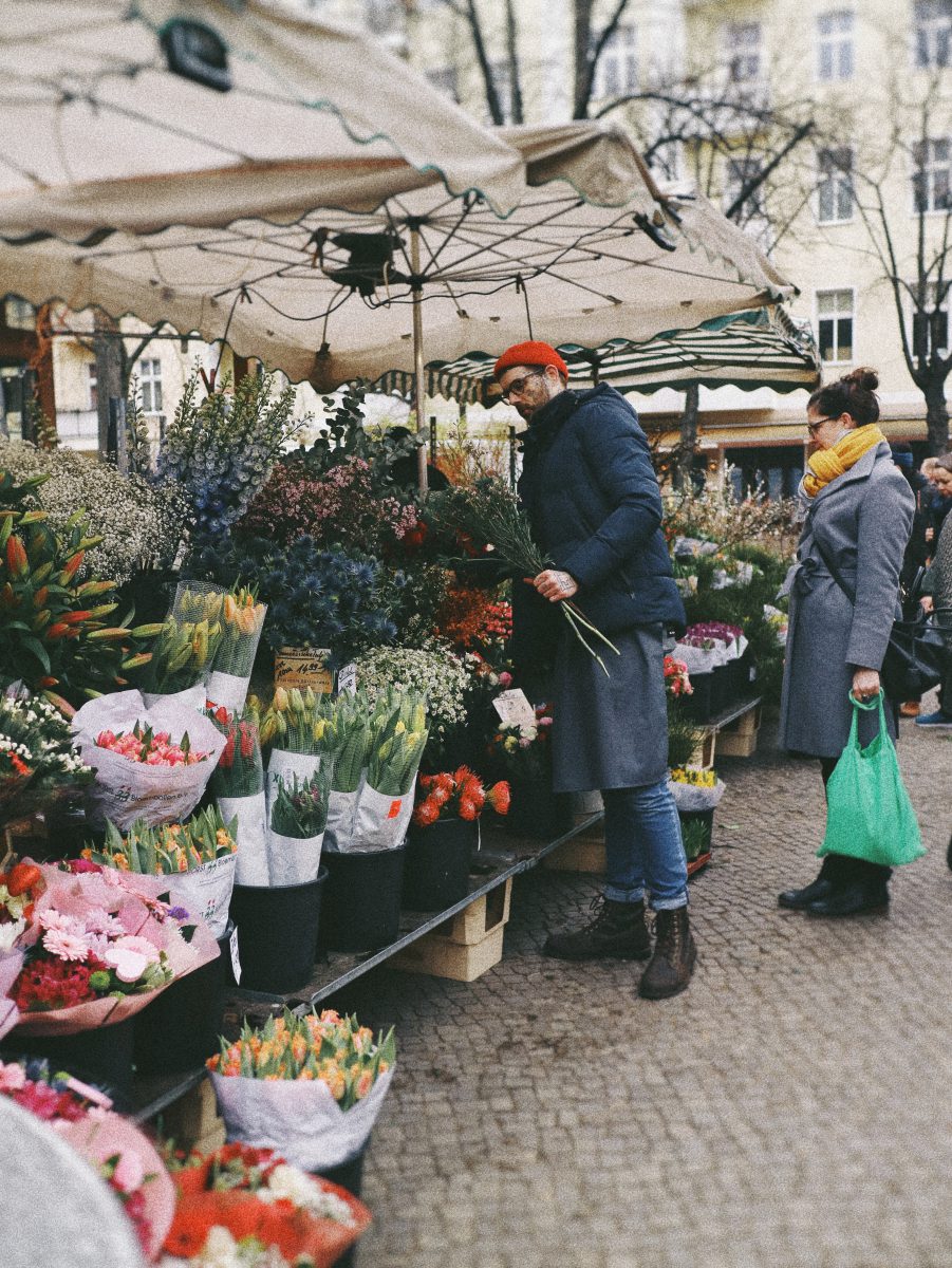 A man and woman at an outdoor flower market.